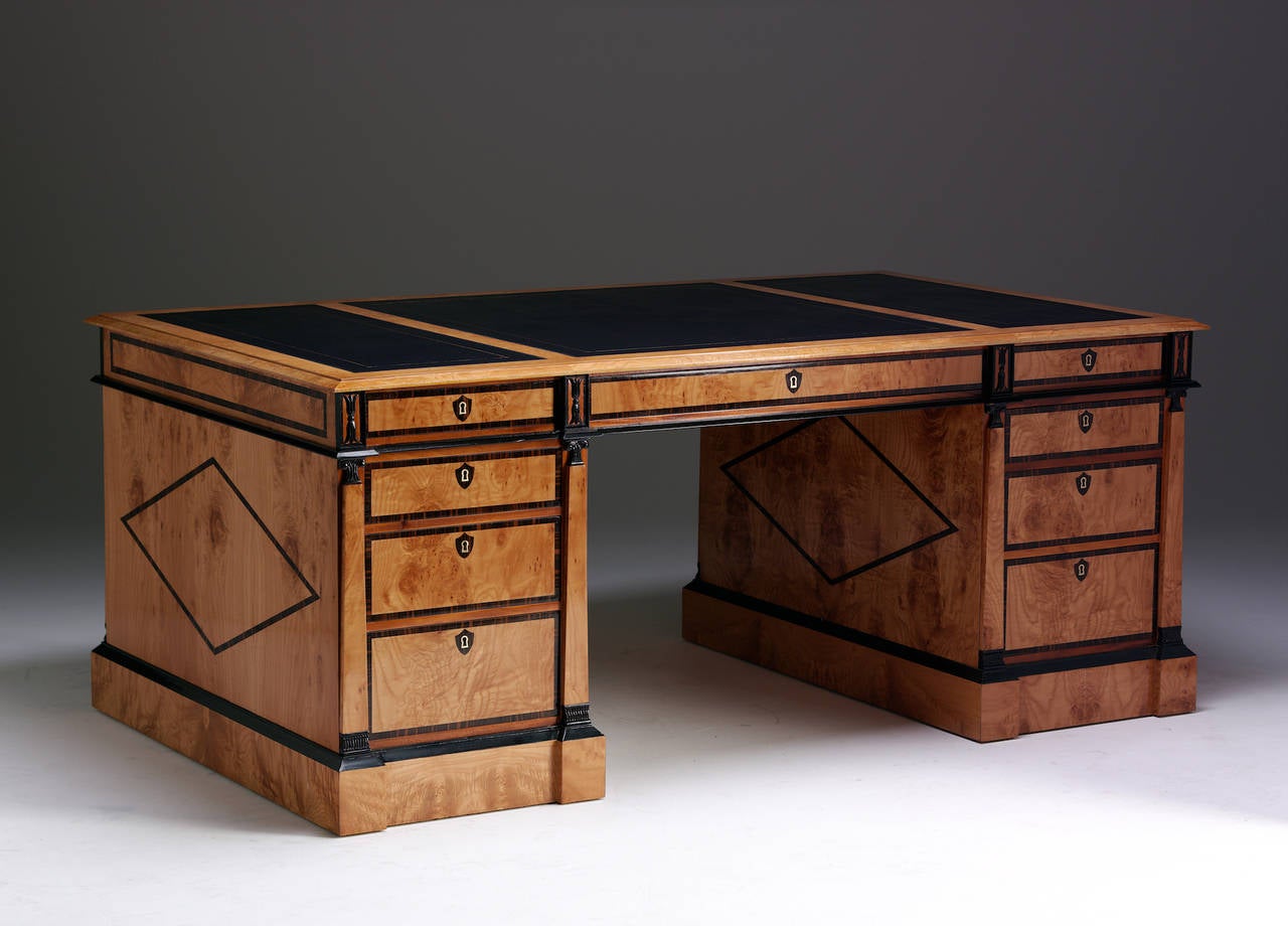 A fine specially selected Baltic birch veneered and ebony decorated partners desk of pleasing proportions and scale, finished with a hand tooled leather top.
All working drawers to one side, cupboards to the reverse side. Kneehole clearance:  25