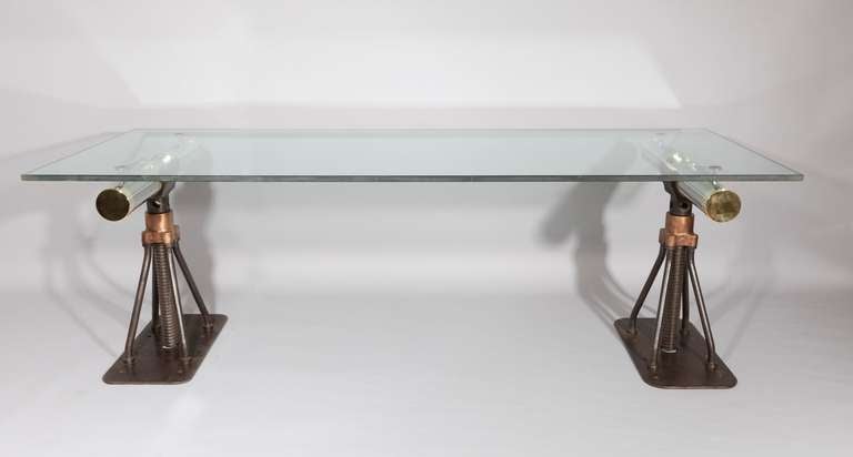 Iron and Bronze adjustable cable drum stands from the finest era of British engineering. They have been converted for a table with a contemporary shaft design made from polished stainless steel and brass. Each trestle has two mounted pads to support