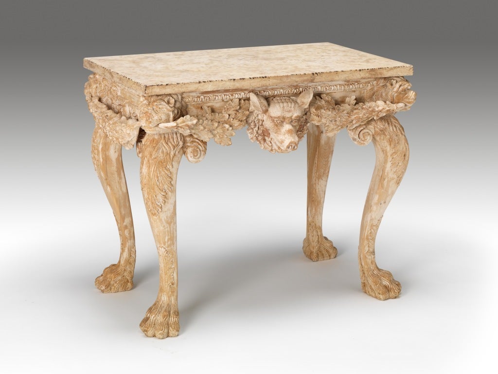 A pair of marble topped side tables. The design inspired by William Kent with central boars head, lion masks, oak leaf garlands and acanthus carved cabriole legs on oversized hairy paw feet. 

These tables were made by the exceptional workshop of