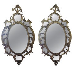 A fine pair of 18th c. giltwood oval mirrors in the manner of Chippendale