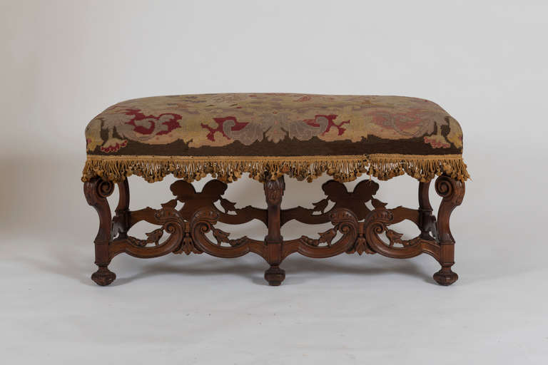 The rectangular seat with period petit point needlework depicting courting figures; raised on elaborate scroll form supports joined by stretchers.