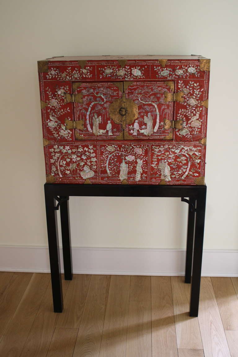 Each stand inlaid with mother-of-pearl Court figures under arching trees and floral and foliate decoration.  Mounted with original brass hinges and lock. The original use for these was as scroll cabinets; the ebonized stands with fretwork spandrels