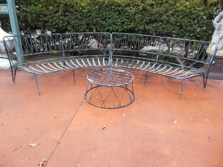 A mid century modern wrought iron 3 pc patio set by Tempistini of Florence for  Salterini.
This set is in the hard to find and desirable ribbon pattern, consisting of 2 curved benches and a round coffee table in need of a glass top.
The 3 pieces