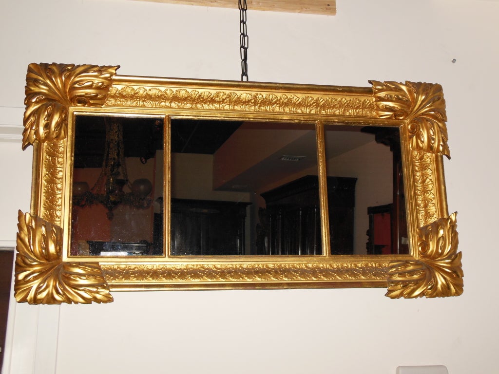 An American Classical mantel mirror with robustly carved acanthus corners, maintains brilliant and unrestored gilt frame.