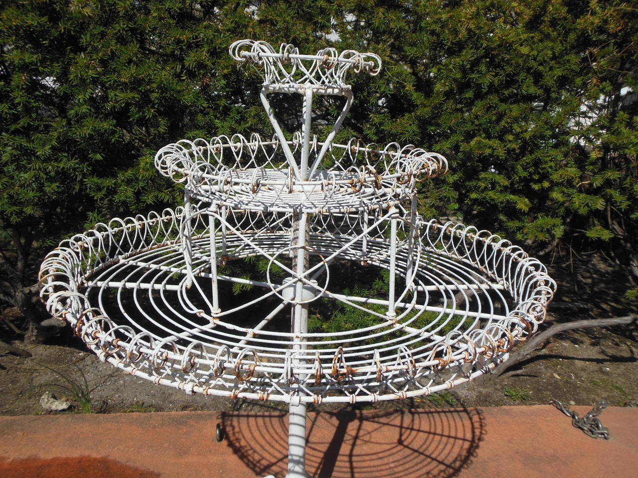 This rare revolving plant stand would be wonderful with trailing flowers and foliage. The plant stand has a Rococo cast iron tripod base, topped with three tiers of curled wire to hold your plants. A mate to this planter can be seen in the