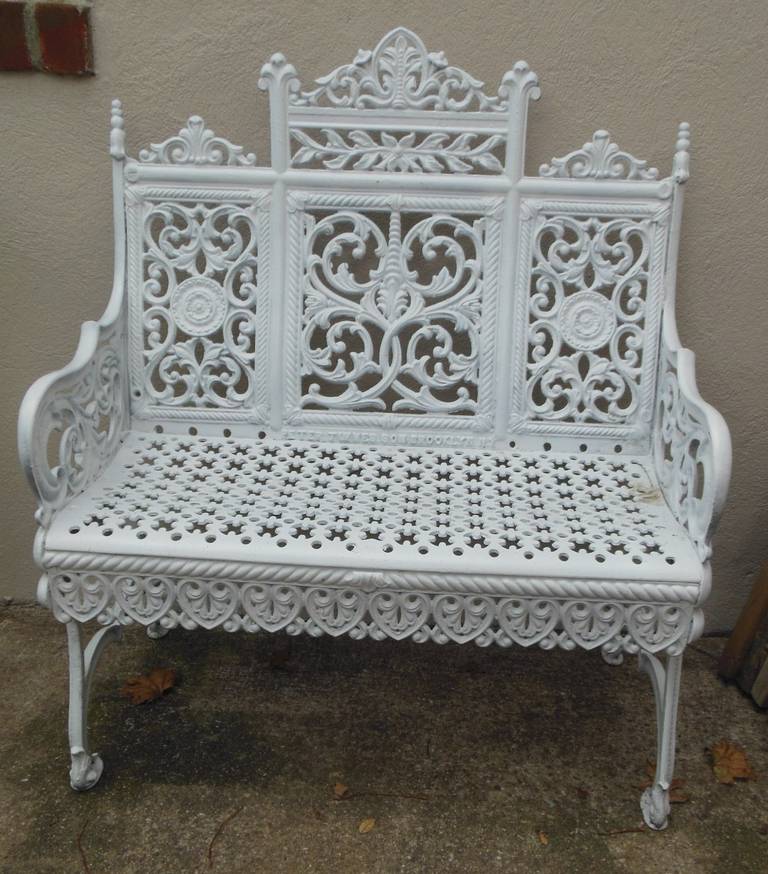 A fancy cast iron garden bench made in Brooklyn New York and patent dated 1895 by Peter Timmes Son. This filigree patterned bench is the most elaborate of a school of benches made in New York City in the late 19thC and commonly referred to as the