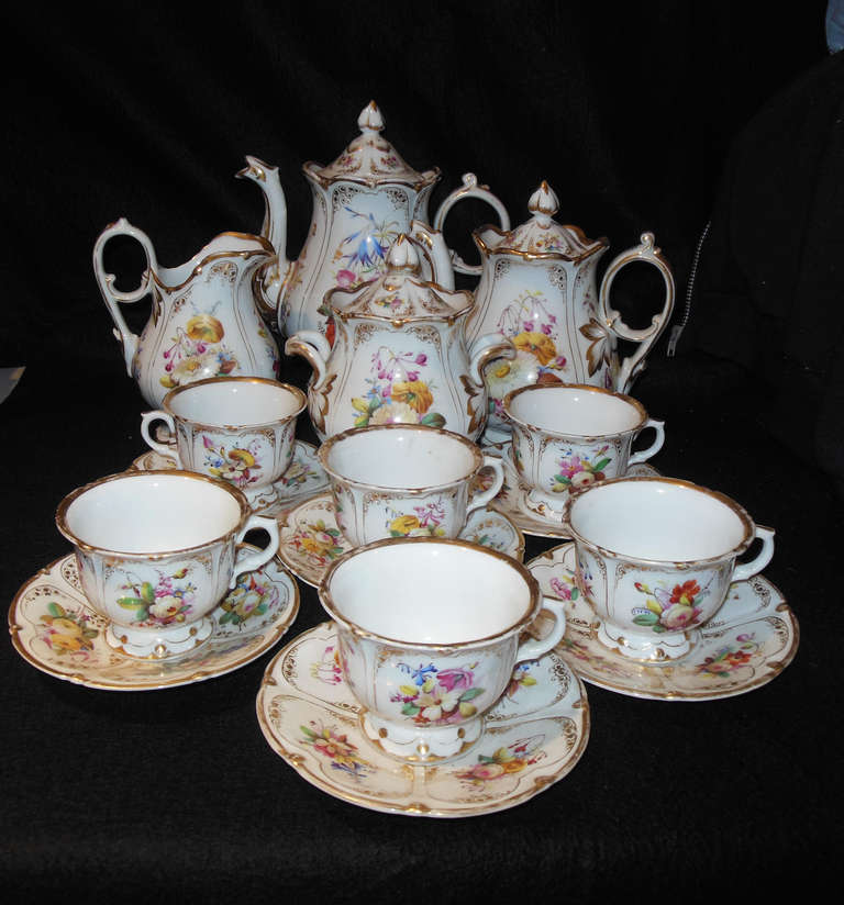 A beautiful Rococo tea set with floral decoration and gilt trim, with
expected wear to the gilt. The set consists of tea and coffee pots, both with covers, a creamer and covered sugar. There are six
cups and saucers. All the above beautifully