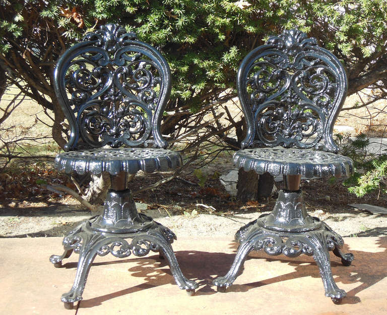 An ornate pair of American cast iron swivel chairs, which are Rococo in style. The chairs have just been cleaned and repainted and are in great condition.