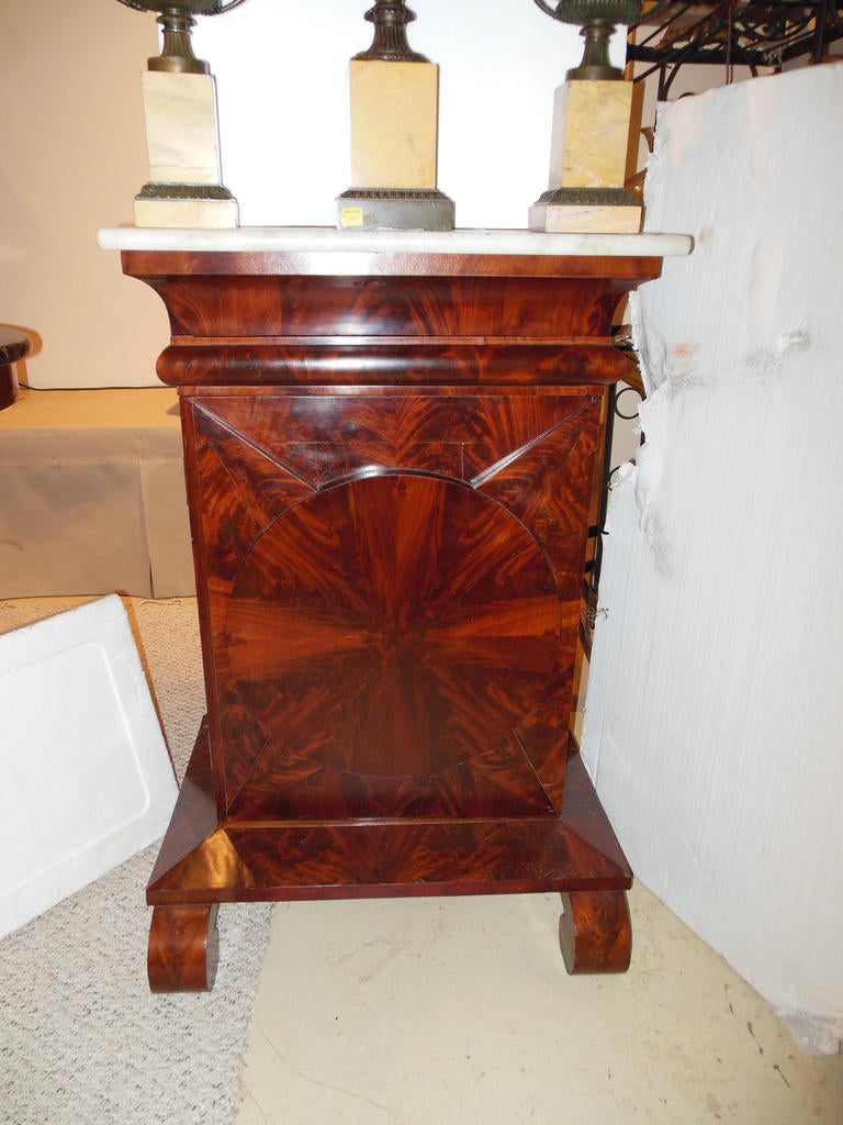 An American Classical cabinet with original white marble top
The door to the cabinet with highly figured bookmatched mahogany flamed veneers, The cabinet is probably from the mid Atlantic states.
The cabinet is a desirable smaller size for a