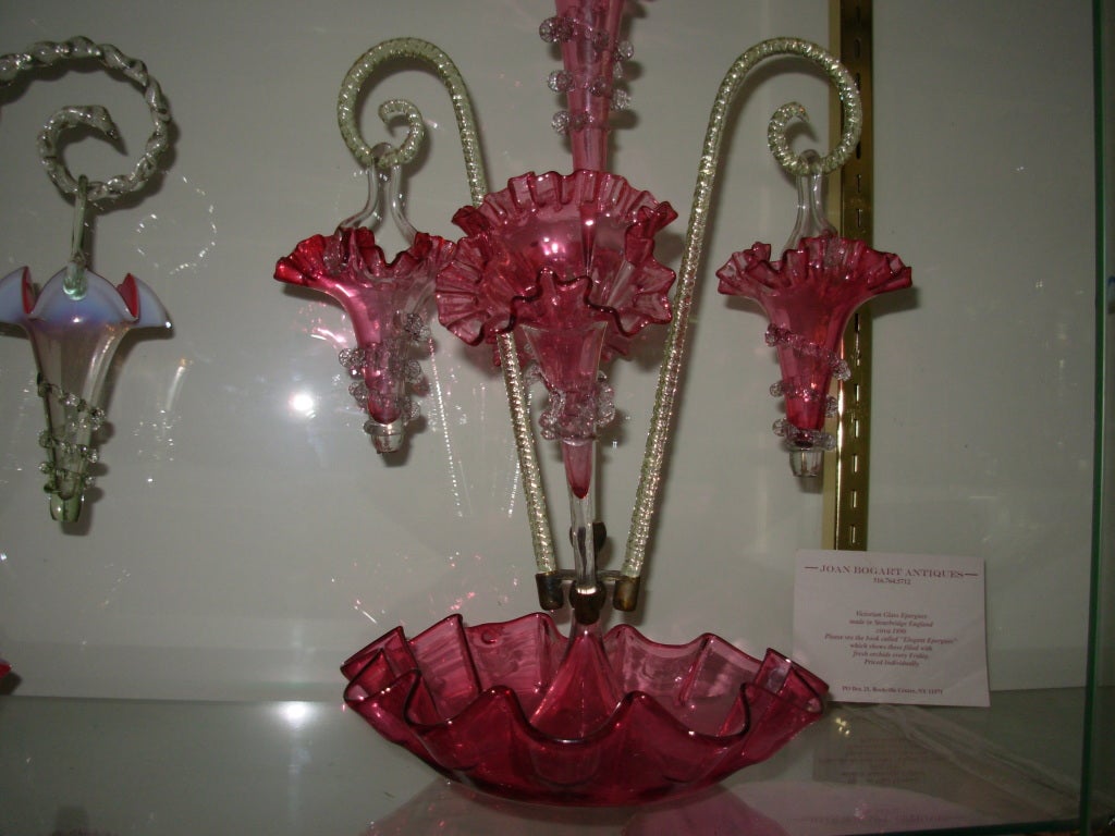 A wonderful Victorian Cranberry Epergne from Stourbridge England, with three tulips and two canes from which hang two cranberry baskets. This is a real beauty and it has become impossible to get these anymore. The condition is almost perfect. There