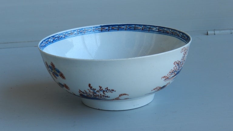 This is a Philip Christian's Liverpool porcelain bowl of around 1765-1775.  It is English canon-ball pattern with a blue underglaze and red and gold overglaze decoration.  Hand painting of pagodas and bonsai trees are on the body of the bowl and a