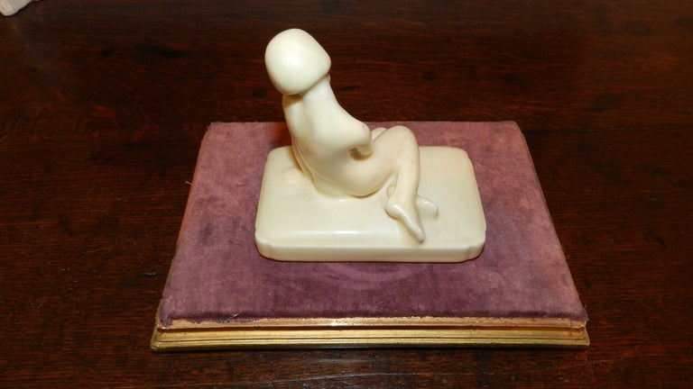 This is a 1929 Rookwood Art Deco seated nude figurine by Bob Cut.  Attributions to  Rookwood are evident to  the underside of the base being marked with an 