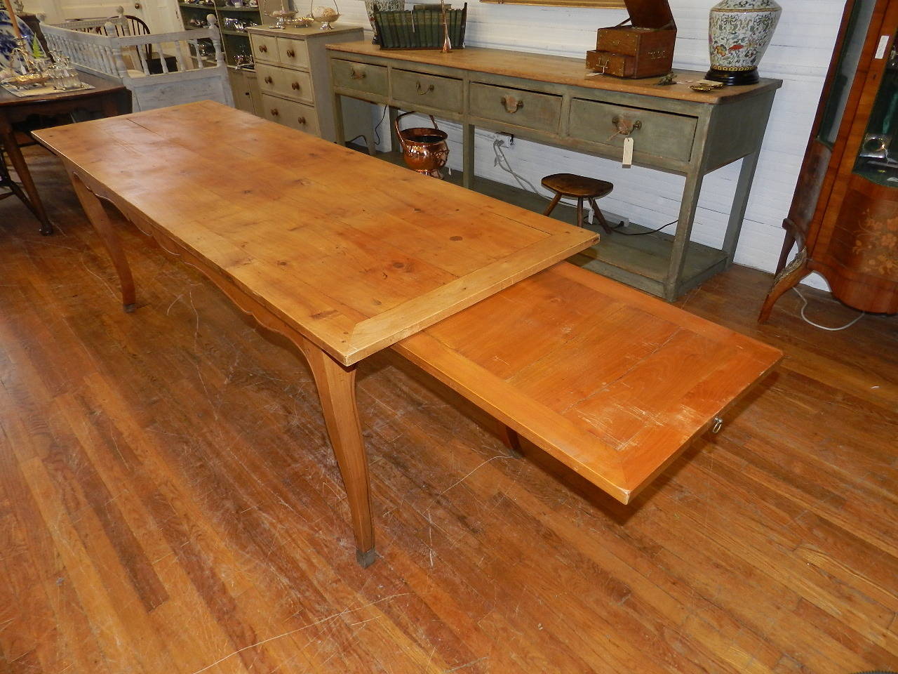 French cherry table with pull-out extensions. Shaped and carved apron supported upon French shaped cabriole legs. All joints are pinned.