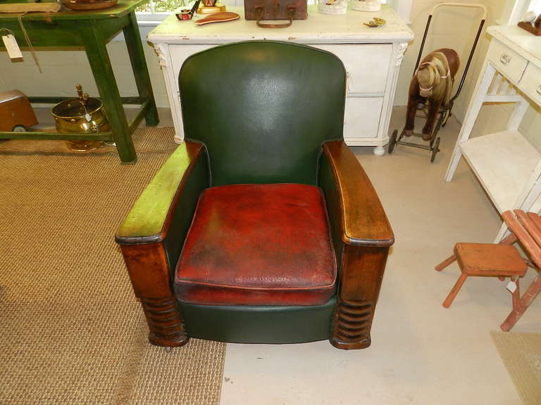 1930's art deco style armchair.It is covered with green and red leatherette vinyl.The frame is solid oak.The cushion shows signs of wear which add to the desirability of the piece.