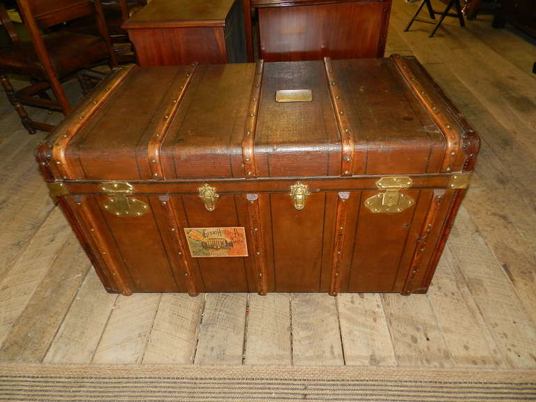 French Oak travelling trunk with original canvas cover,brass locks and leather carrying handles. The trunk is bound with oak straps.The interior has two original removable trays .The original  owner's brass name plaque is on the lid..