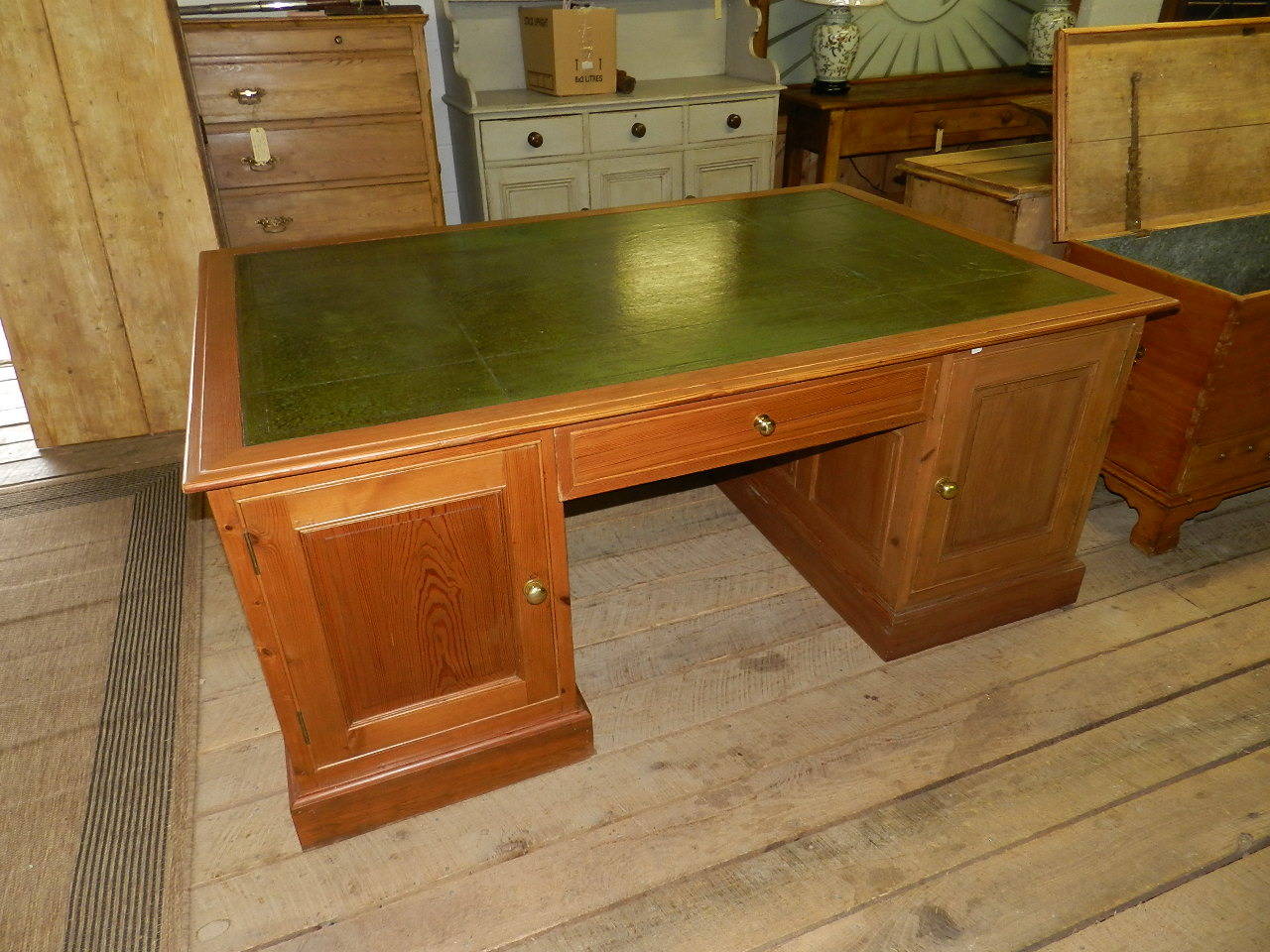 Antique pine twin pedestal desk with olive green tooled leather top. The large drawers have been adapted to accept modern files. The center section has a secret locking mechanism.