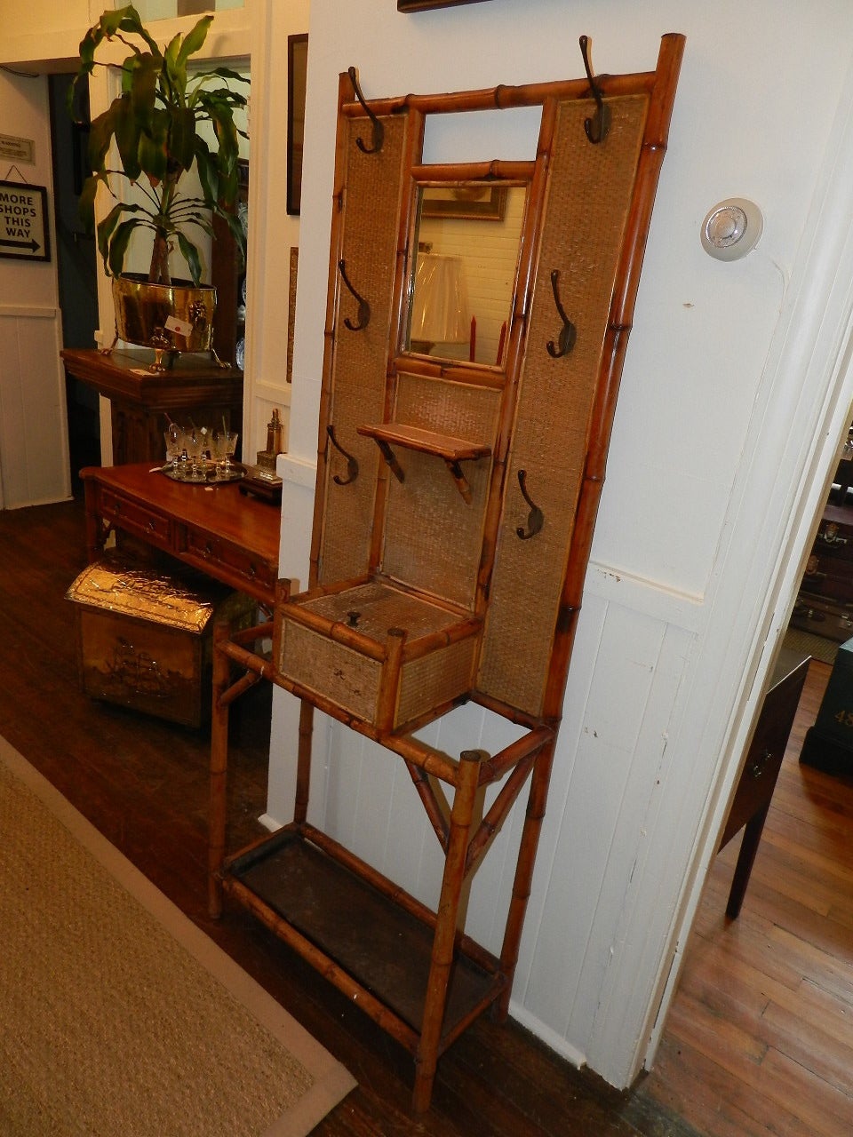 Bamboo coat/hat rack with six iron coat hooks,mirror and glove box.There are  two compartments for walking sticks or umbrellas .The original metal drip tray is still present.