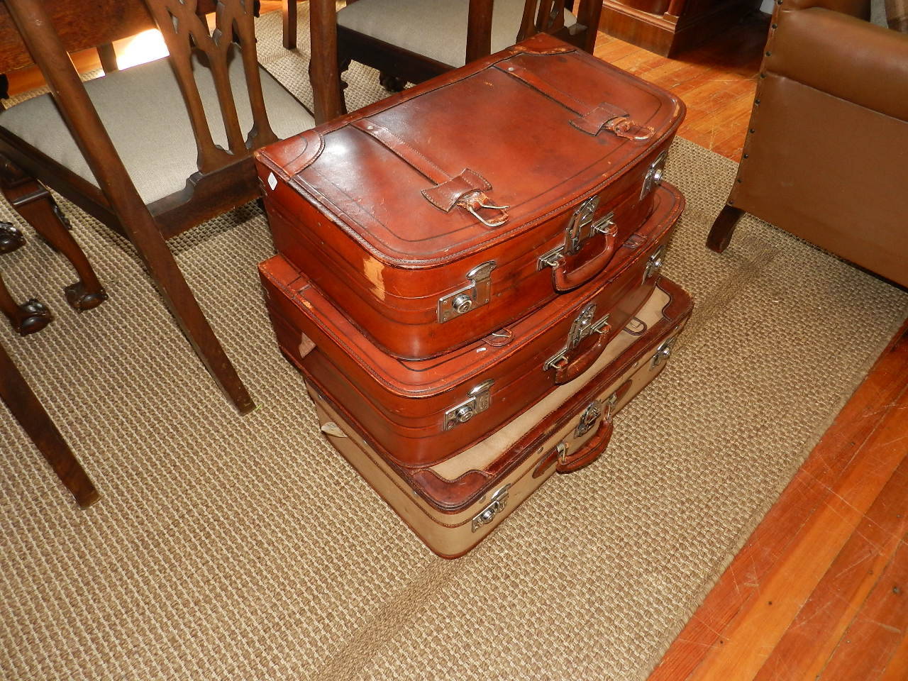 A set of three vintage leather and canvas  suitcases