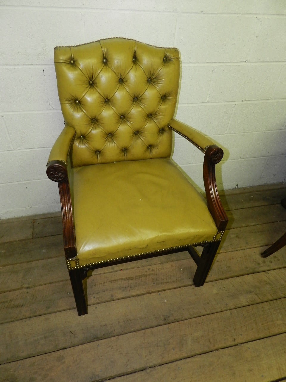 Mahogany framed gainsborough style chair with buttoned and studded leather upholstery.