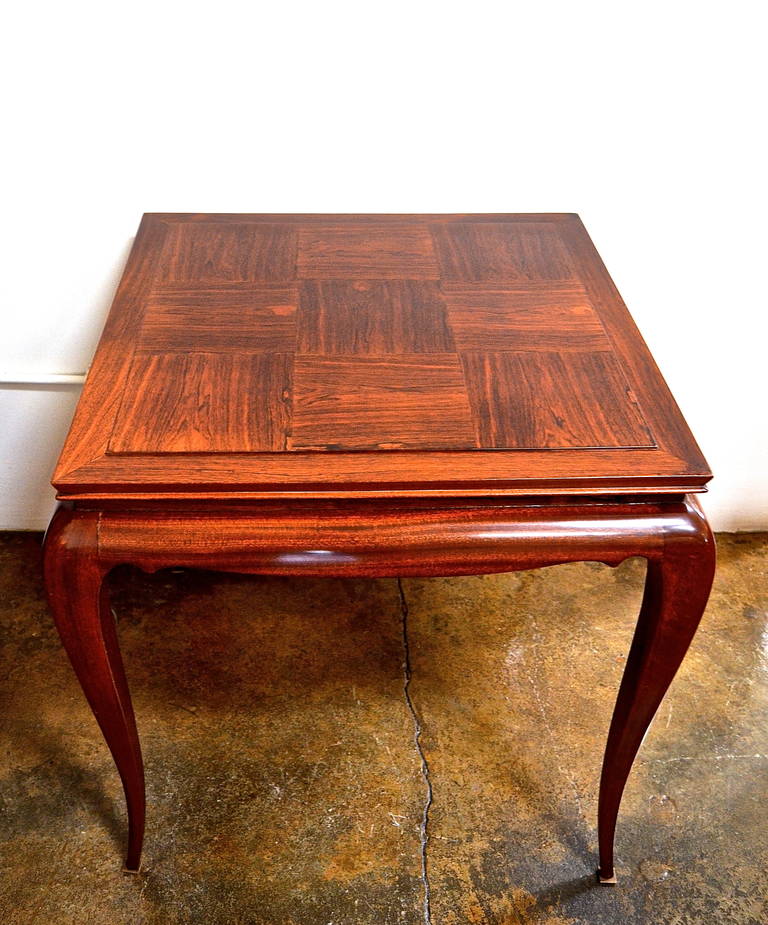 A gorgeous René Prou palisander games table with bronze sabot.
A convertible felt top lies below a hand polished parquetry top. A needlepoint table cover is also included. Very chic.
