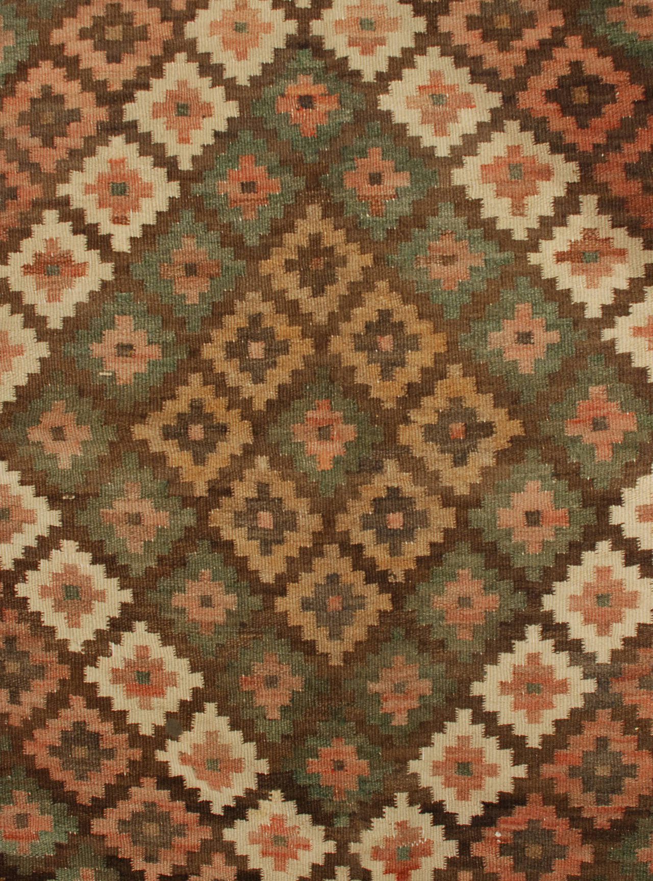 An early 20th century Persian, Saveh Kilim rug with three large diamond medallions consisting of alternating multicolored geometric motifs, surrounded by complementary geometric borders.