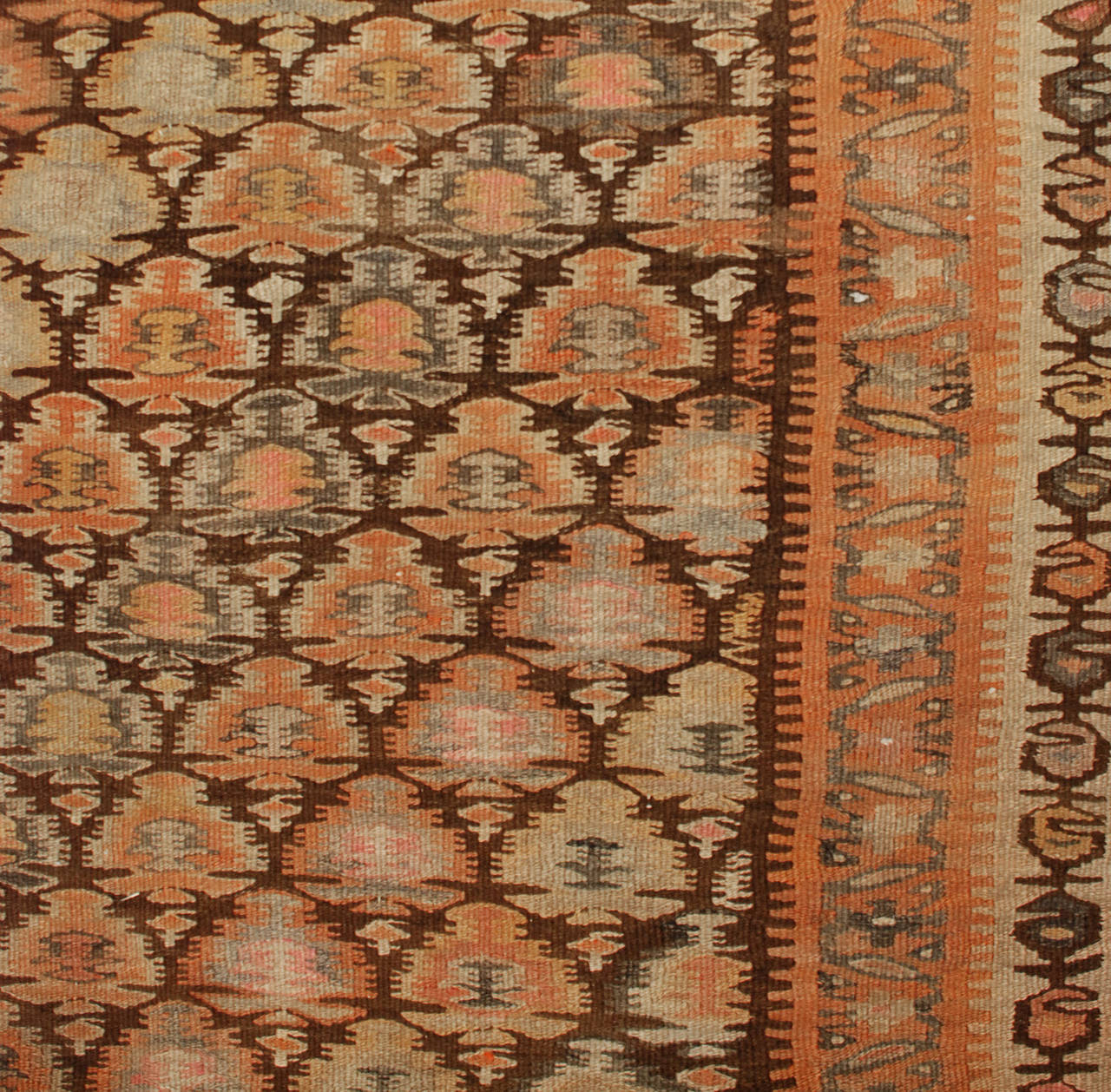 An early 20th century Persian Qazvin Kilim runner with alternating multicolored tree-of-life pattern surrounded by multiple complementary floral and geometric borders.