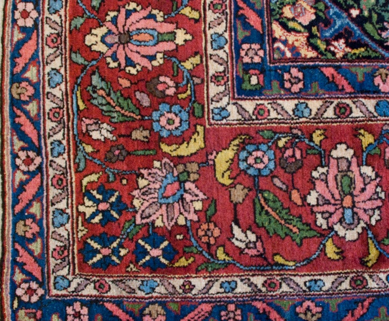An early 20th century Persian Bakhtiari carpet with all-over ornately woven tree of life and bird of paradise pattern, surrounded by a floral border. 10'7