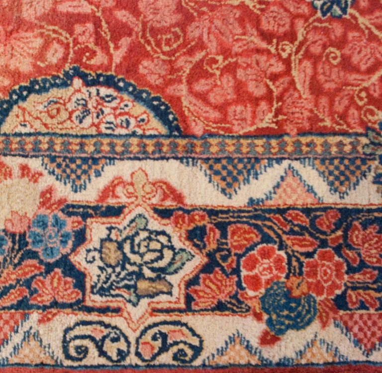 An early 20th century Persian Sarouk carpet runner with wonderfully intricate pattern on a crimson background surrounded by a floral and paisley border. Measures: 5.8