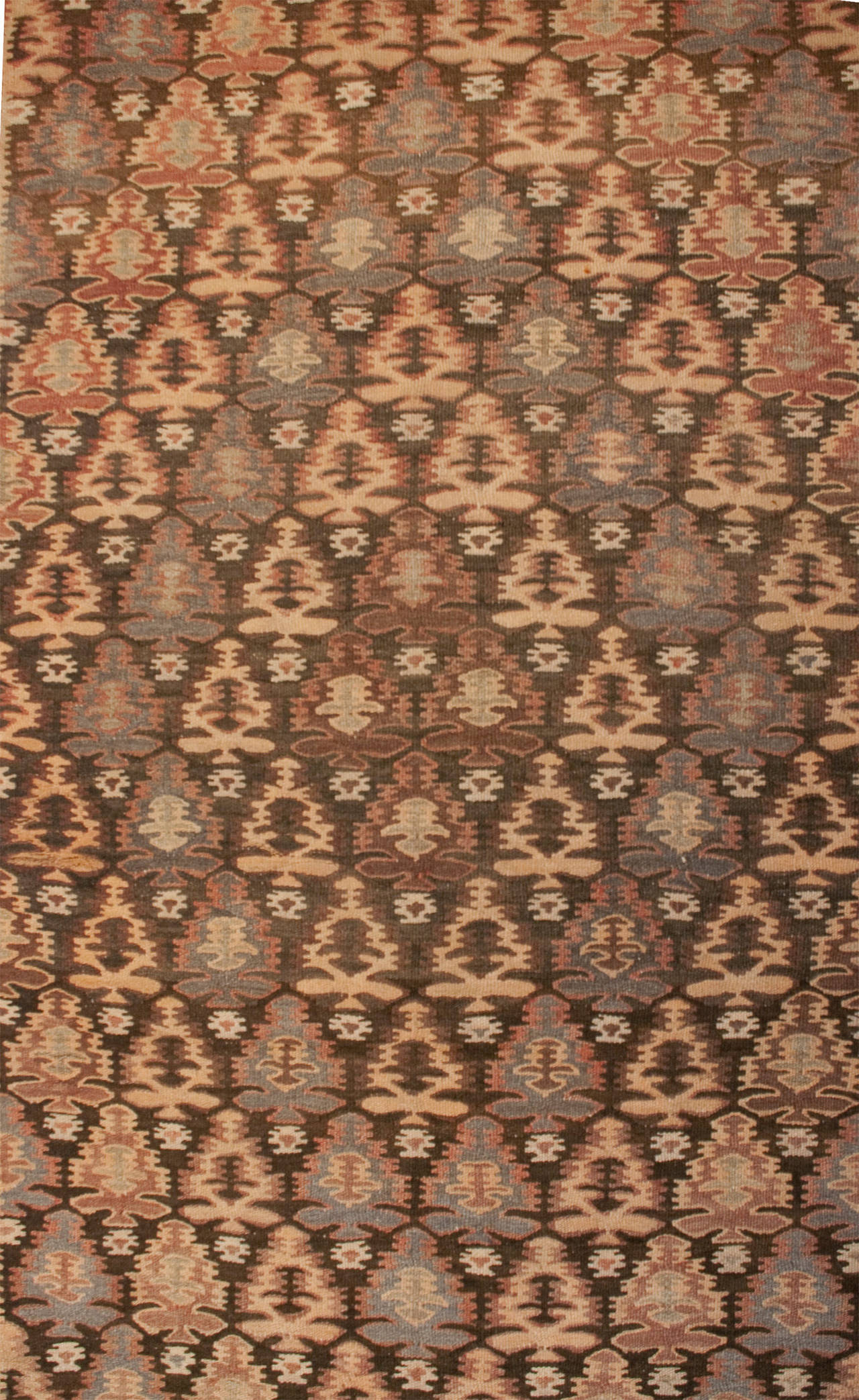 An early 20th century Persian Qazvin Kilim runner with a wonderful all-over multicolored floral pattern surrounded by a complementary geometric border.