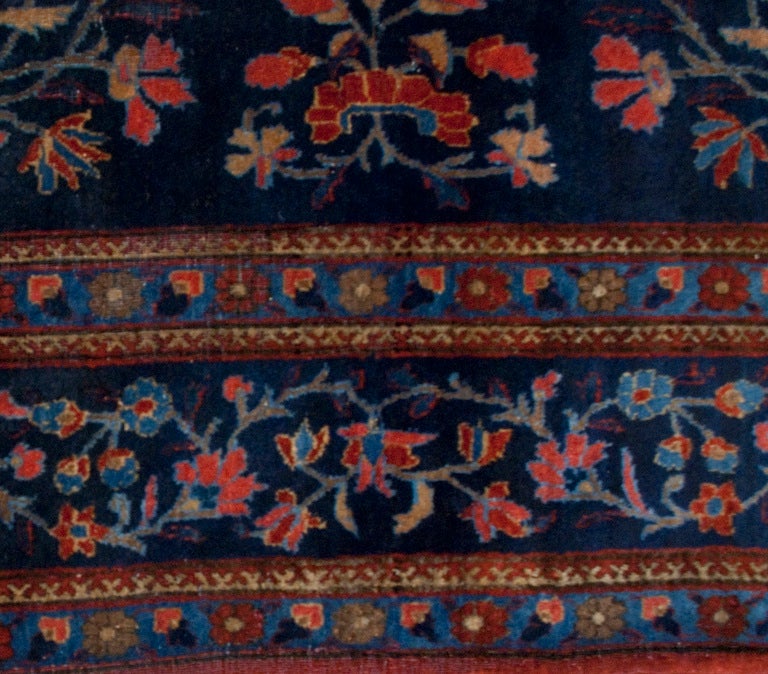 An early 20th century Persian Kashan carpet with all-over floral pattern on a dark indigo background surrounded by a floral border.
Measures: 4'4