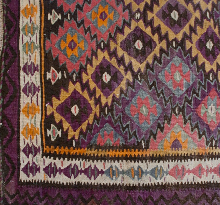 An early 20th century Persian Qazvin Kilim carpet runner with all geometric diamond pattern surrounded by a zigzag border.
Measures: 3'9
