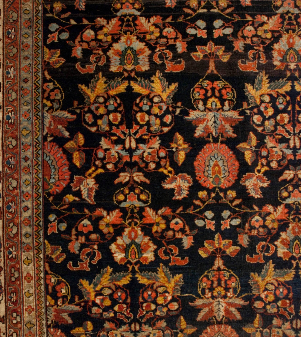 A late 19th century Persian Kashan rug with a wonderful multicolored tree-of-life pattern on a rich indigo background, surrounded by a contrasting floral border.
