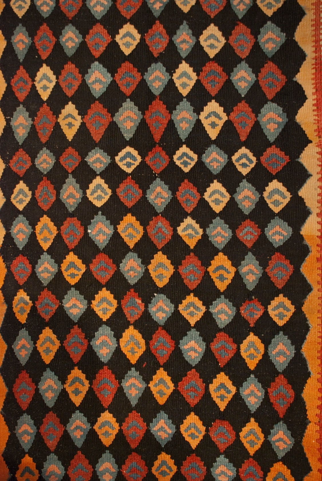 An early 20th century Persian, Harsin Kilim runner with a wonderful, all-over, multicolored diamond pattern surrounded by multiple contrasting geometric borders.