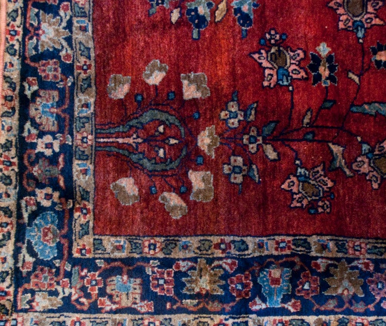 A late 19th century Persian Sarouk Mohajeran rug with central floral field on a crimson background, surrounded by a contrasting floral border.
Measures: 3.2