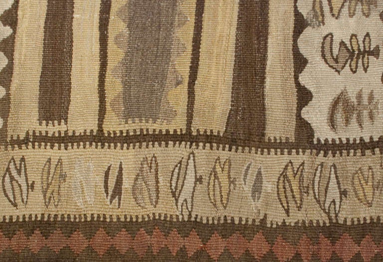 An early 20th century Persian Zarand Kilim runner with multiple alternating striped and floral pattern in natural un-dyed wool.