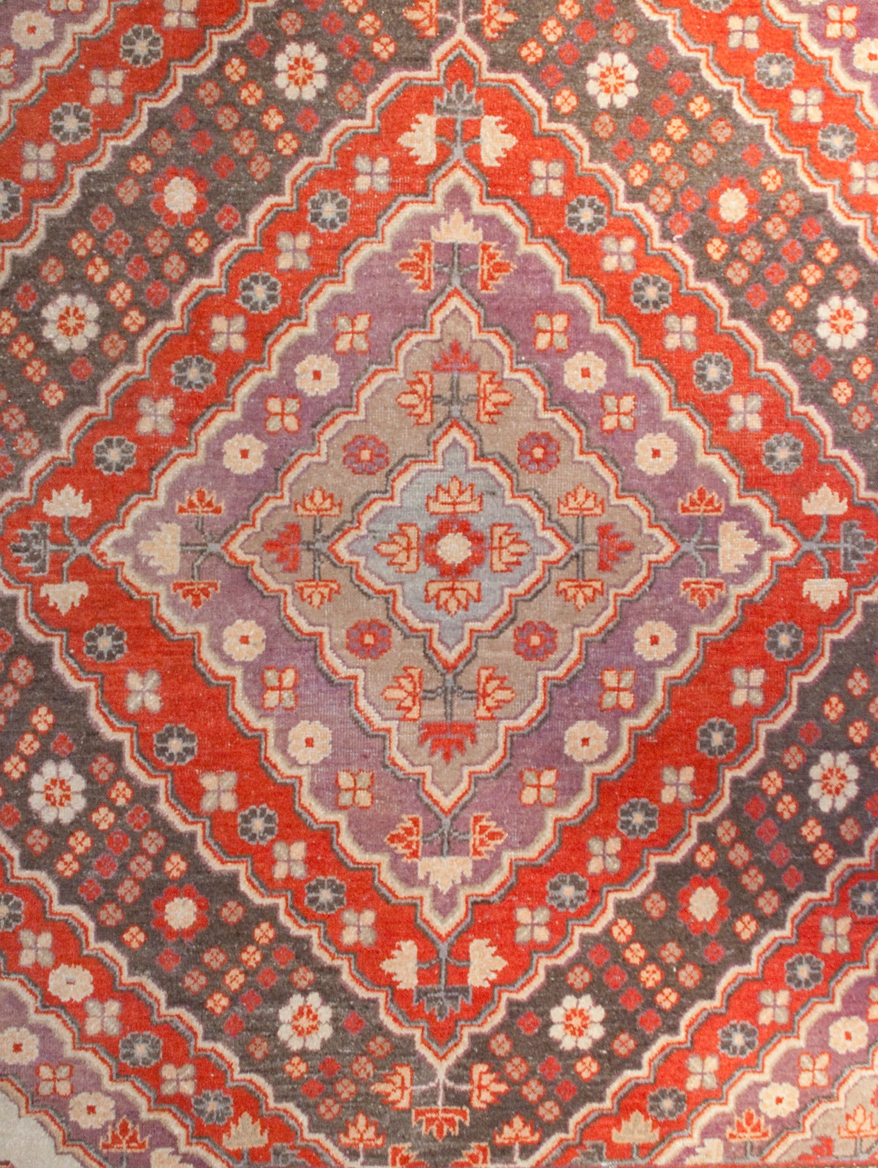 An amazing early 20th century monumental Central Asian Samarkand rug with multiple diamond medallions amidst a densely woven field of flowers, surrounded by multiple complementary floral borders.