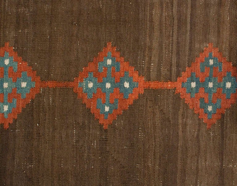 An early 20th century Persian Shahsavan runner with multiple crimson and indigo diamond patterns on a natural wool background surrounded by two geometric borders.