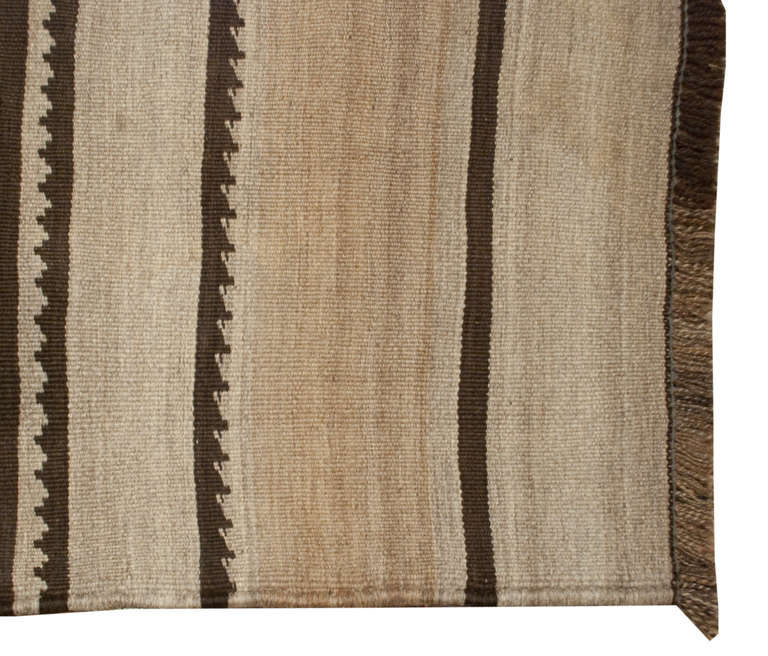 Un antique tapis persan Lori avec un motif géométrique asymétrique multicolore et un motif rayé tissé en laine naturelle.