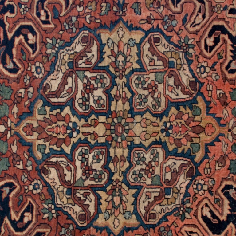 A 19th century Persian Saruk Farahan carpet with central medallion on a background of pale red with floral and vine motifs, surrounded by a contrasting floral border.



Measures: 11.7