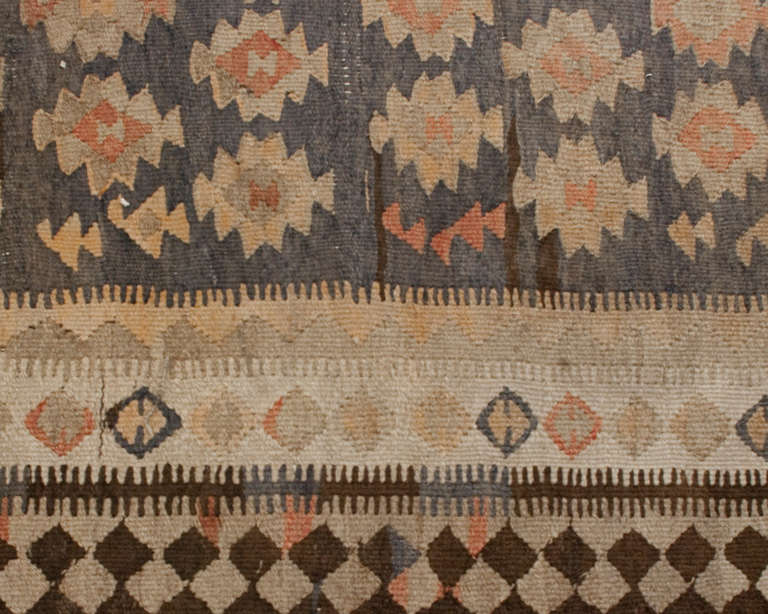 An early 20th century Persian Zarand Kilim runner with all-over geometric floral pattern woven in natural un-dyed wool, surrounded by multiple complementary borders.