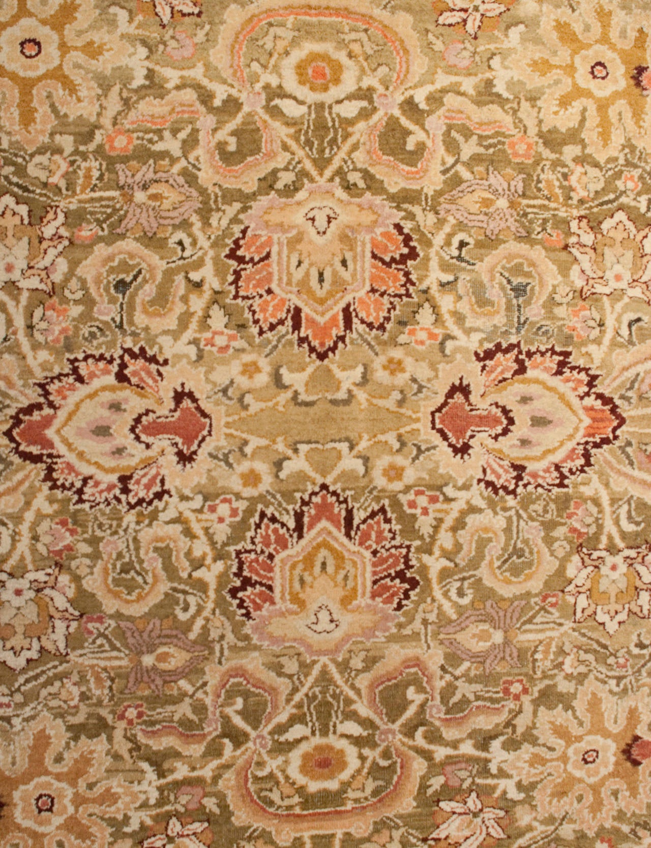 An early 20th century Indian Agra rug with an intricately woven multicolored floral pattern on a chartreuse green background, surrounded by multiple complementary multicolored floral borders.