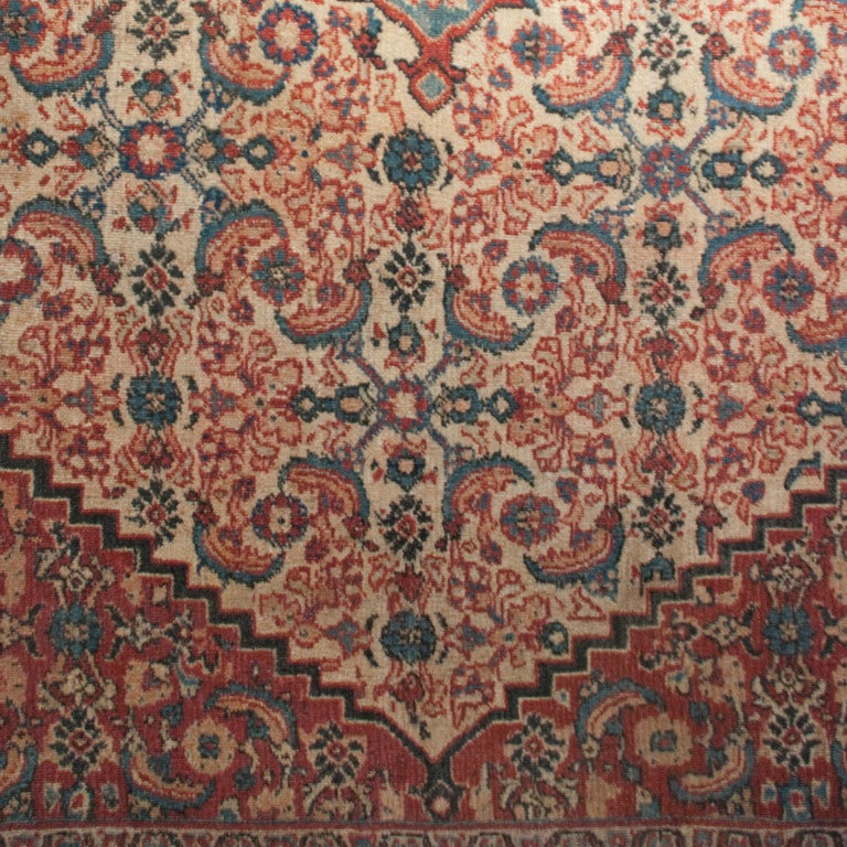 An early 20th century Persian Doroksh Herati carpet with compound central diamond medallions on a background of densely patterned florals, with a contrasting indigo and floral border.

Measures: 10'2