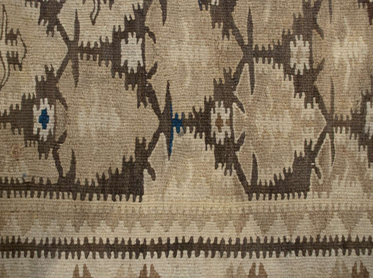 An early 20th century Persian Qazvin Kilim runner with all-over geometric floral pattern surrounded by multiple complementary borders, in natural wool.