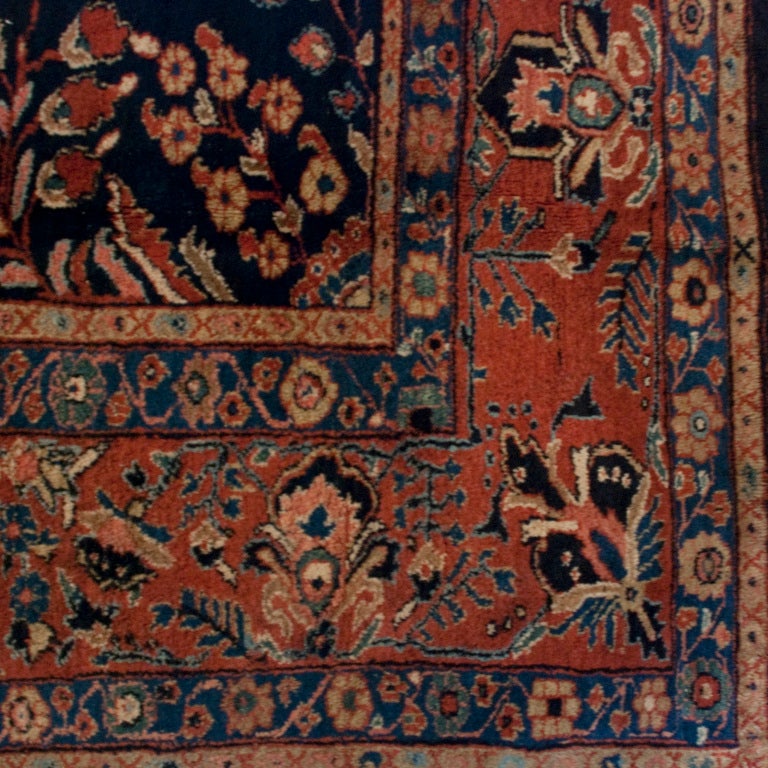An early 20th century Persian Saruk Mahajan carpet with all over tree of life pattern on a navy blue background, surrounded by a contrasting floral and vine pattern border.

Measures: 8.10