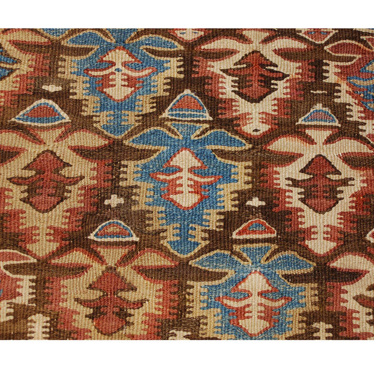 An early 20th century Persian Qazvin kilim runner with beautiful all-over stylized floral pattern of alternating indigo, dark red, and natural wool diagonal stripes, surrounded by multiple complementary floral borders.