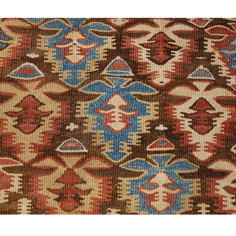 Ein persischer Qazvin-Kelim-Läufer aus dem frühen 20. Jahrhundert mit einem schönen stilisierten Blumenmuster aus abwechselnd indigoblauen, dunkelroten und natürlichen diagonalen Wollstreifen, umgeben von mehreren komplementären Blumenborten.