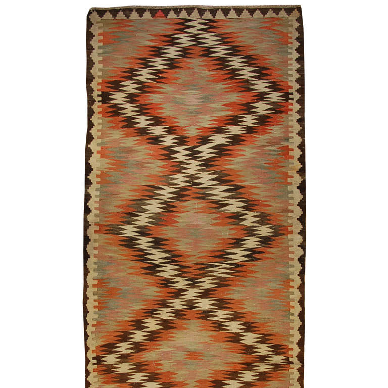 An early 20th century Persian Kilim runner with alternating zigzag pattern surrounded by a complementary zigzag border.