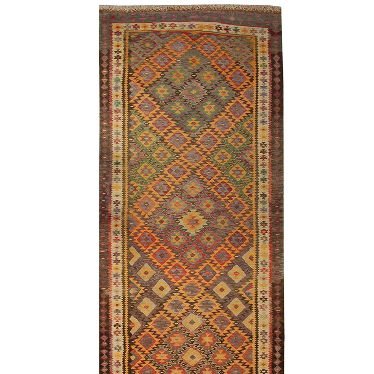 A wonderful early 20th century Persian Qazvin kilim runner with multi-colored geometric and diamond zigzag pattern surrounded by a contrasting geometric border.