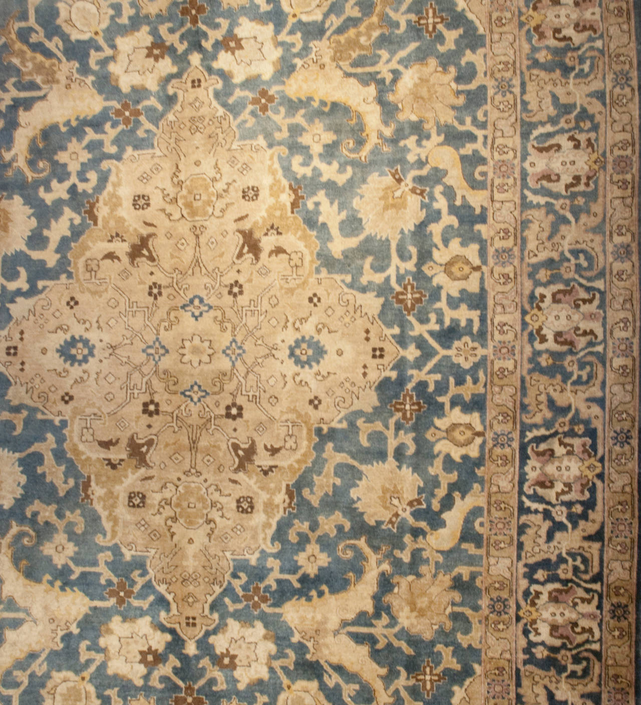 An early 20th century Persian Tabriz rug with a large central medallion on a beautiful all-over scrolling vine and field of flowers surrounded by multiple complementary floral borders.