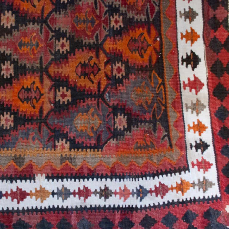 A mid-20th century Persian Kazvin Kilim carpet with all-over multicolored geometric pattern with contrasting border.

Measures: 4' x 10'6